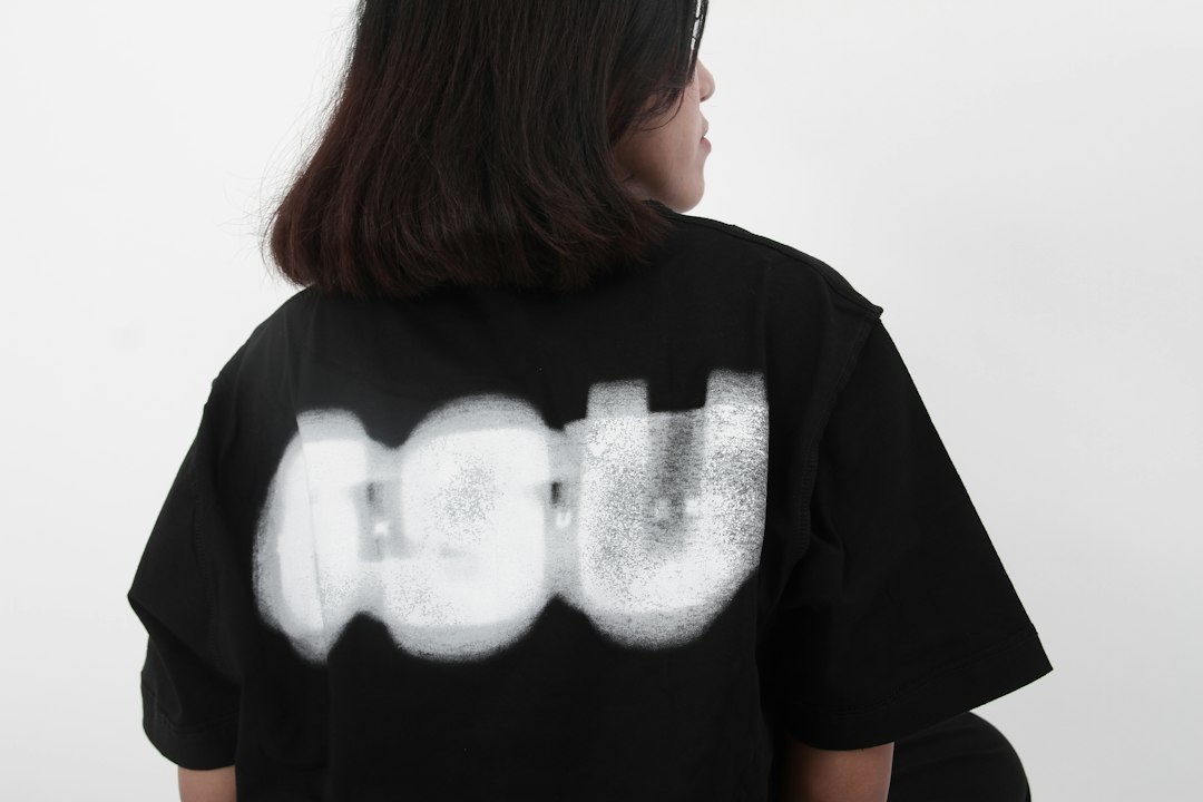 A person wearing a black t-shirt with abstract white design
